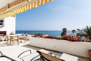 a patio with a table and chairs and the ocean at Coral Beach Aparthotel in Marbella