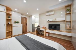 een slaapkamer met een bed en een bureau met een televisie bij Nikko Hotel - The Classy Life in Ho Chi Minh-stad