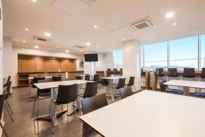 uma sala de conferências com mesas e cadeiras e uma televisão em Comfort Inn Delicias em Delicias