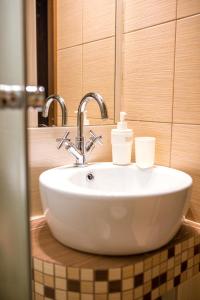 a bathroom sink with two cups on top of it at Pokoje Gościnne u Meresa in Żywiec