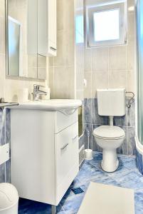 bagno con lavandino bianco e servizi igienici di Apartmani Stella a Drage
