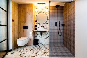 uma casa de banho com um WC e um chuveiro com um espelho. em Białka Residence Ski - Apartamenty Ski Resort em Białka Tatrzanska
