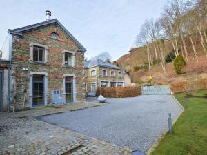 een stenen huis met een oprit ervoor bij Splendid ground floor apartment with garden in the very center of Spa in Spa