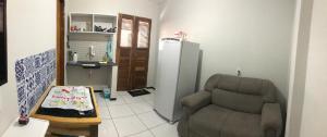 - un salon avec une chaise et un réfrigérateur dans l'établissement Aconchego em Parnaiba jw, à Parnaíba