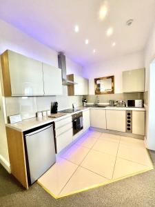 a kitchen with white cabinets and a purple ceiling at Large Luxury Apartment Blackpool in Blackpool