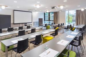 una classe con tavoli, sedie e schermo di proiezione di MAXX by Steigenberger Vienna a Vienna