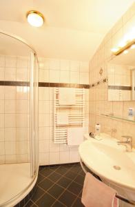 a bathroom with a shower and a sink and a tub at Appartement Hotel Garni Matthäuserhof in Gerlos