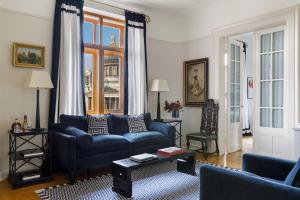 a living room with a blue couch and a window at Rocco Forte Astoria Hotel in Saint Petersburg