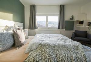 a bedroom with a bed and a chair and a window at Charmante Ferienwohnung mit Sauna und Schwimmbad im zauberhaften Bayerischen Wald in Sankt Englmar