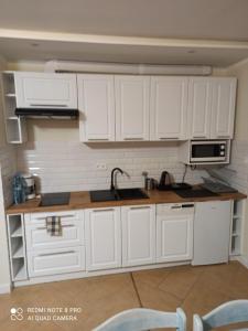 a kitchen with white cabinets and a sink at Panorama Lake Resort in Nowe Guty
