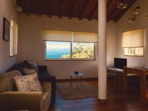 a living room with a couch and a large window at Quinta das Almas in São Roque do Pico