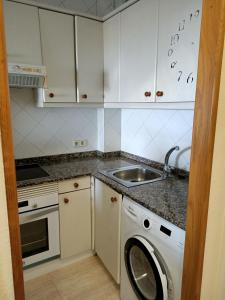 een keuken met een wasmachine en een wastafel bij Beautiful first line beach apartment Samil in Vigo