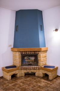 a living room with a stone fireplace with two benches at Pokoje Gościnne u Meresa in Żywiec