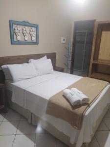 裴尼多的住宿－Pousada Casa do Bosque，一间卧室配有一张大床和毛巾