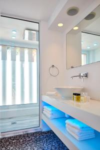 a bathroom with a sink, mirror and tub at So White Club Resort in Ayia Napa