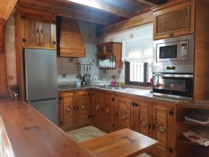 a kitchen with wooden cabinets and stainless steel appliances at El Nogal in Ronda