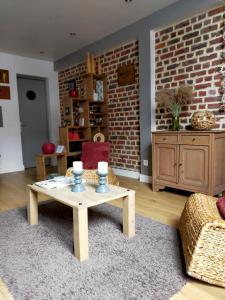a living room with a coffee table and a brick wall at spéculoos et chicorée in Villeneuve d'Ascq
