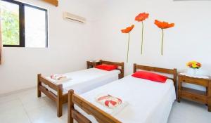 2 camas en una habitación con flores en la pared en Evi Apartments And Studios, en Theologos