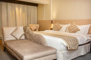 ein Hotelzimmer mit einem großen Bett und einem Stuhl in der Unterkunft Haven Plaza in Riad