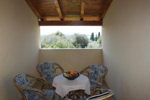 a table with chairs and a bowl of fruit on it at Apartments Drandic in Fažana