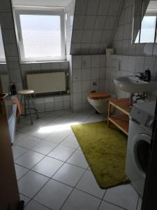 La salle de bains est pourvue d'un lavabo, de toilettes et d'une fenêtre. dans l'établissement Ferienwohnung Poehlmann, à Plauen