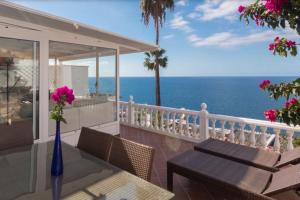 a balcony with a table and chairs and the ocean at Sunset Balcony with Ocean Views and pool access in Mogán