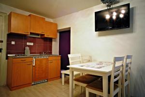 cocina con mesa y sillas y TV en la pared en Studio Erika 189, en Rovinj