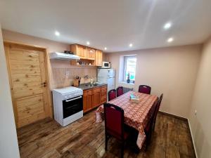 a kitchen with a table and a kitchen with a table and chairs at Мальовица - къща за гости in Dospey Makhla