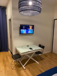 Biały stół z krzesłami i telewizor na ścianie w obiekcie Futura Exclusive Suite 3 w mieście Bari +7 zdjęć