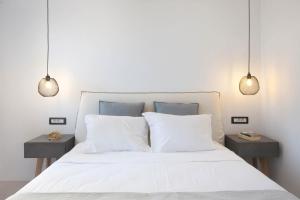 アンティパロス・タウンにあるKouros Villageのベッドルーム1室(白いベッド1台、ナイトスタンド2台付)