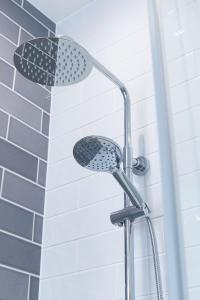 a shower with a shower head in a bathroom at Panmure Apartment in Monifieth