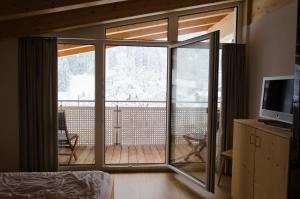 a room with a sliding glass door leading to a deck at Appartements SILVA in Hopfgarten im Brixental