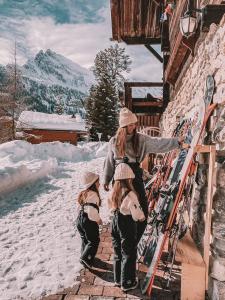 een vrouw en twee meisjes in de sneeuw met ski's bij Mountain Hostel Gimmelwald in Gimmelwald