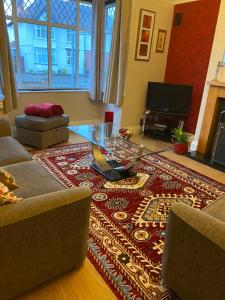 ein Wohnzimmer mit einem Tisch und einem Teppich in der Unterkunft Goldcrest House by RentMyHouse in Hereford