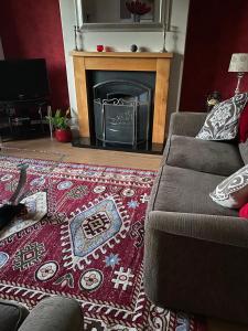 a living room with a couch and a fireplace at Goldcrest House by RentMyHouse in Hereford