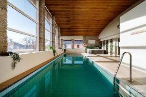 a swimming pool in a house with a wooden ceiling at Hotel Garzon Plaza in Győr