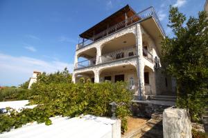 an old house with a balcony on top of it at Murter Inn in Murter