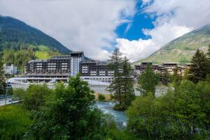 a resort with a river in front of a mountain at TH La Thuile - Planibel Residence in La Thuile