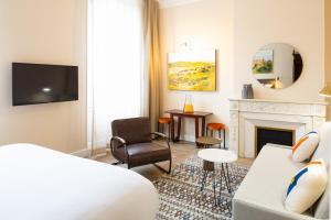 une chambre d'hôtel avec un lit et une cheminée dans l'établissement Hôtel Maison Montgrand - Vieux Port, à Marseille