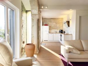 a living room with a couch and a kitchen at Villa Sandrose in Nideggen