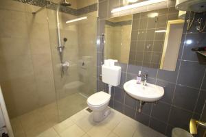 een badkamer met een toilet, een douche en een wastafel bij Murter Inn in Murter