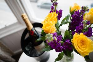 a vase filled with yellow and purple flowers next to a window at Gwesty'r Marine Hotel & Spa in Aberystwyth