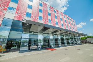a large glass building with a bench in front of it at Premier Kraków Hotel in Krakow