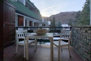 a table and two chairs on a balcony with a view at Appartamento La Pigna - Affitti Brevi Italia in Bardonecchia