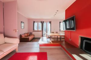 een woonkamer met een rode muur en een tv bij Appartamento La Pigna - Affitti Brevi Italia in Bardonecchia