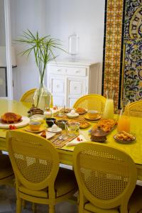 una mesa de comedor amarilla con sillas y comida. en Dar Marsa Cubes, en La Marsa