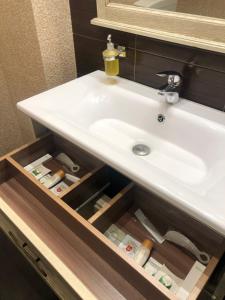 Un lavabo con un cajón con botellas debajo. en Nab Hotel Taganskaya en Moscú