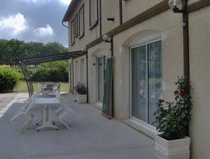 eine Terrasse mit einem weißen Tisch außerhalb eines Gebäudes in der Unterkunft Chambres d'hôtes Les Lavandes Rocamadour in Rocamadour