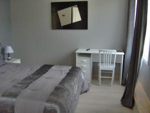 um quarto com uma cama e uma secretária com uma cadeira em Chambres d'hôtes Les Lavandes Rocamadour em Rocamadour