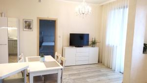 Il comprend un salon doté d'une télévision et d'une table à manger. dans l'établissement Sea Garden Apartment, à Varna